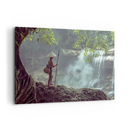 Bild auf Leinwand - Leinwandbild - Eine Figur mit einem Speer an einem Wasserfall in einem tropischen Wald - 120x80cm - Befreundet mit der Natur - Moderne Wanddekoration für Wohnzimmer und Schlafzimmer ARTTOR