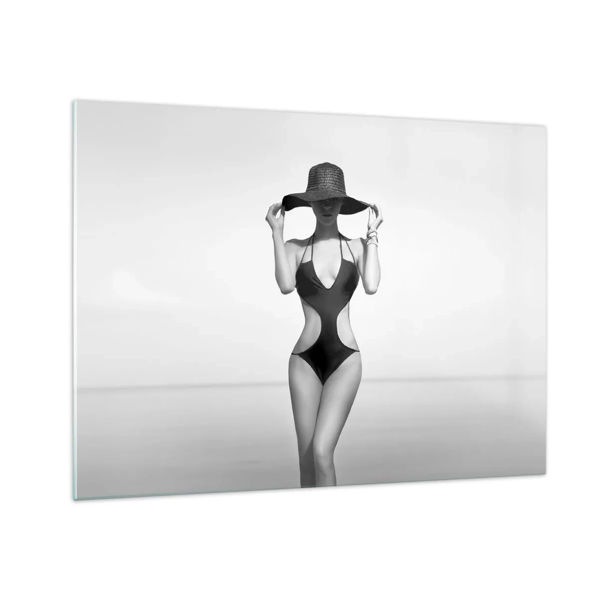 Glasbild - Bild auf glas - Eine Frau in einem schwarzen Badeanzug und Hut vor dem Meer - 70x50cm - Mein Name ist: Eleganz - Moderne Wanddekoration für Wohnzimmer und Schlafzimmer ARTTOR