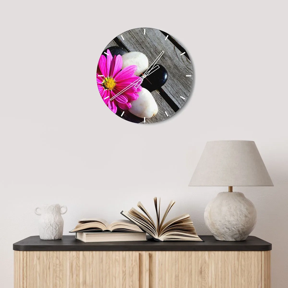 Wanduhr - Glasuhr - Eine rosa Blume vor einem Hintergrund aus Steinen und einem Holzsockel. - 30x30cm - Ruhe auf dem Pier - Moderne Wanddekoration für Wohnzimmer, Küche und Schlafzimmer ARTTOR