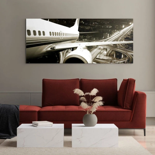 Glasbild - Bild auf glas - Ein Flugzeug über einer nächtlichen Stadt mit beleuchteten Autobahnen - 140x50cm - In die Nacht fliegen - Moderne Wanddekoration für Wohnzimmer und Schlafzimmer ARTTOR