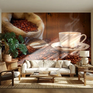 Fototapete Premium Sand - Eine Tasse Kaffee vor einem Hintergrund aus Bohnen und einem Jutebeutel - 100x70cm - Fühlst du diesen Geruch? - Moderne Wanddekoration für Wohnzimmer und Schlafzimmer ARTTOR
