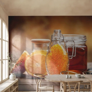 Fototapete Premium Sand - Eine Flasche Orangenöl und ein Glas Honig auf Holz - 100x70cm - Sonnige Aromen und Düfte - Moderne Wanddekoration für Wohnzimmer und Schlafzimmer ARTTOR