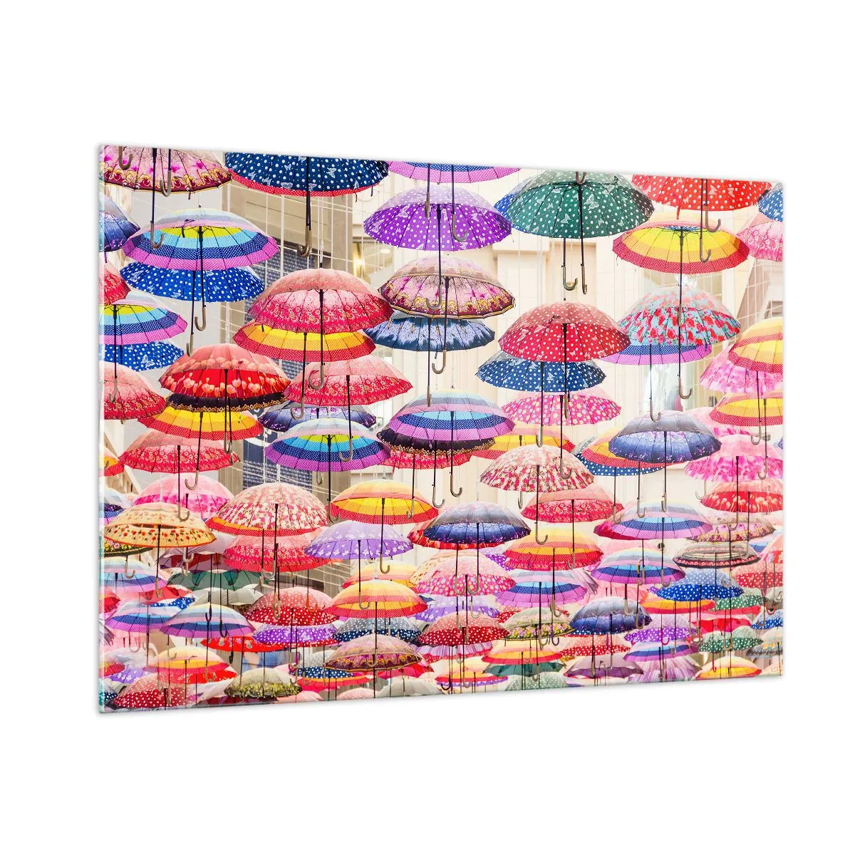 Glasbild - Bild auf glas - Ein Foto von bunten Regenschirmen, die in der Luft hängen. - 100x70cm - Stadtwiese - Moderne Wanddekoration für Wohnzimmer und Schlafzimmer ARTTOR
