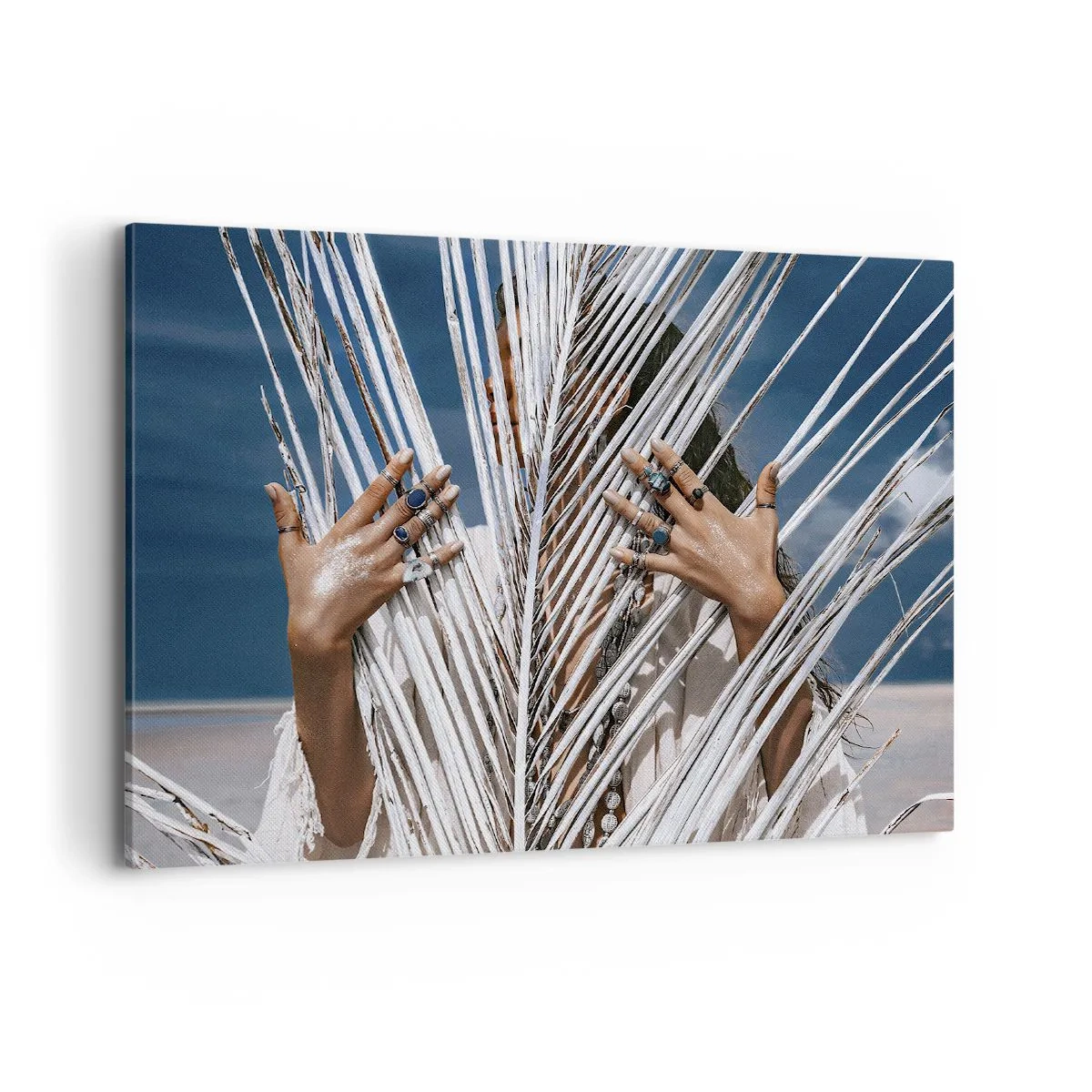 Bild auf Leinwand - Leinwandbild - Eine Frau, versteckt hinter Palmblättern, mit Ringen an den Händen. - 100x70cm - Das Mädchen des Schamanen? - Moderne Wanddekoration für Wohnzimmer und Schlafzimmer ARTTOR