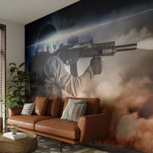 Fototapete Premium Sand - Ein Soldat im Einsatz mit einer Waffe in einer dynamischen Szene - 100x70cm - Nur ein Held - Moderne Wanddekoration für Wohnzimmer und Schlafzimmer ARTTOR