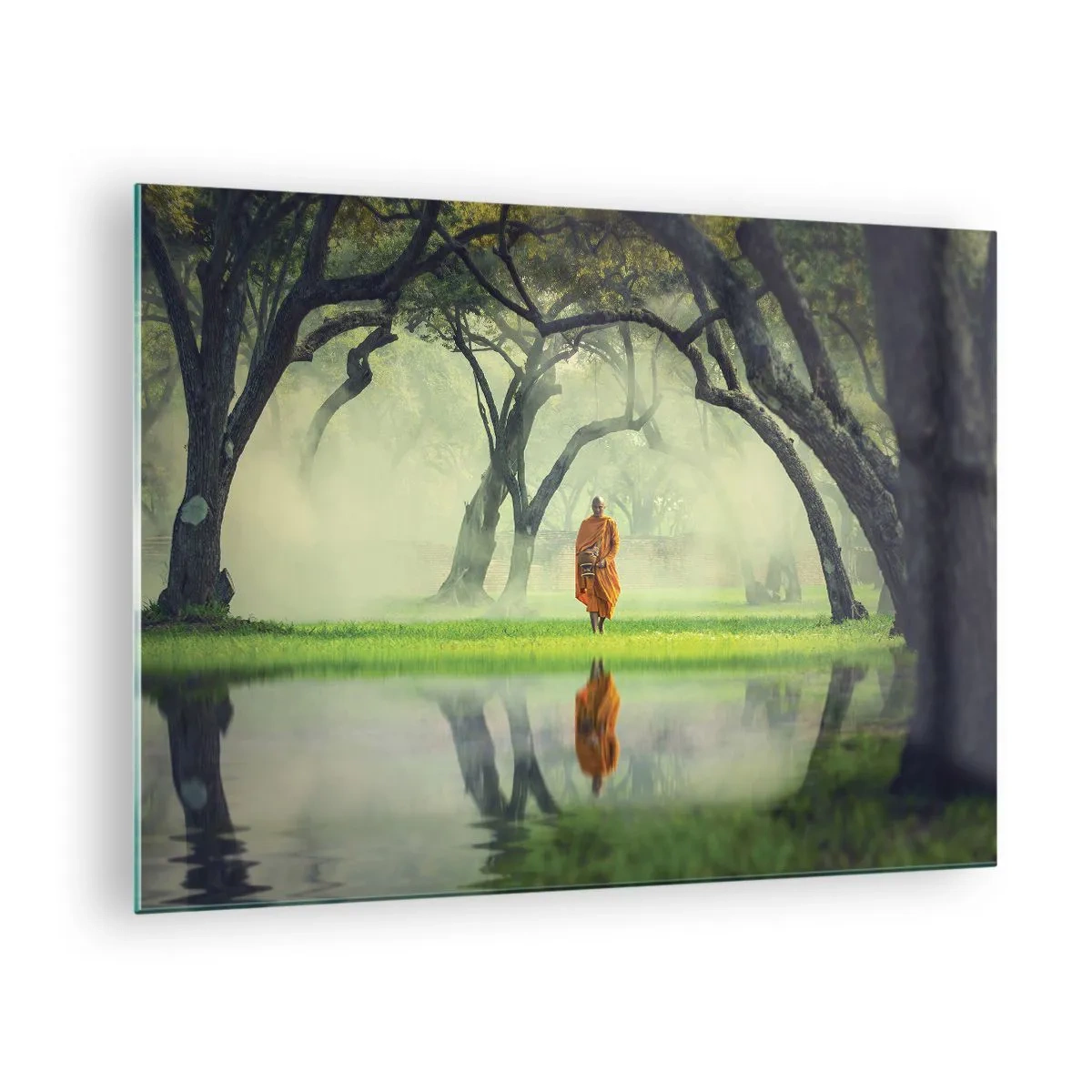 Glasbild - Bild auf glas - Ein Mönch in einer orangefarbenen Robe geht zwischen den Bäumen am Wasser spazieren - 70x50cm - Auf dem Weg zur Erleuchtung - Moderne Wanddekoration für Wohnzimmer und Schlafzimmer ARTTOR