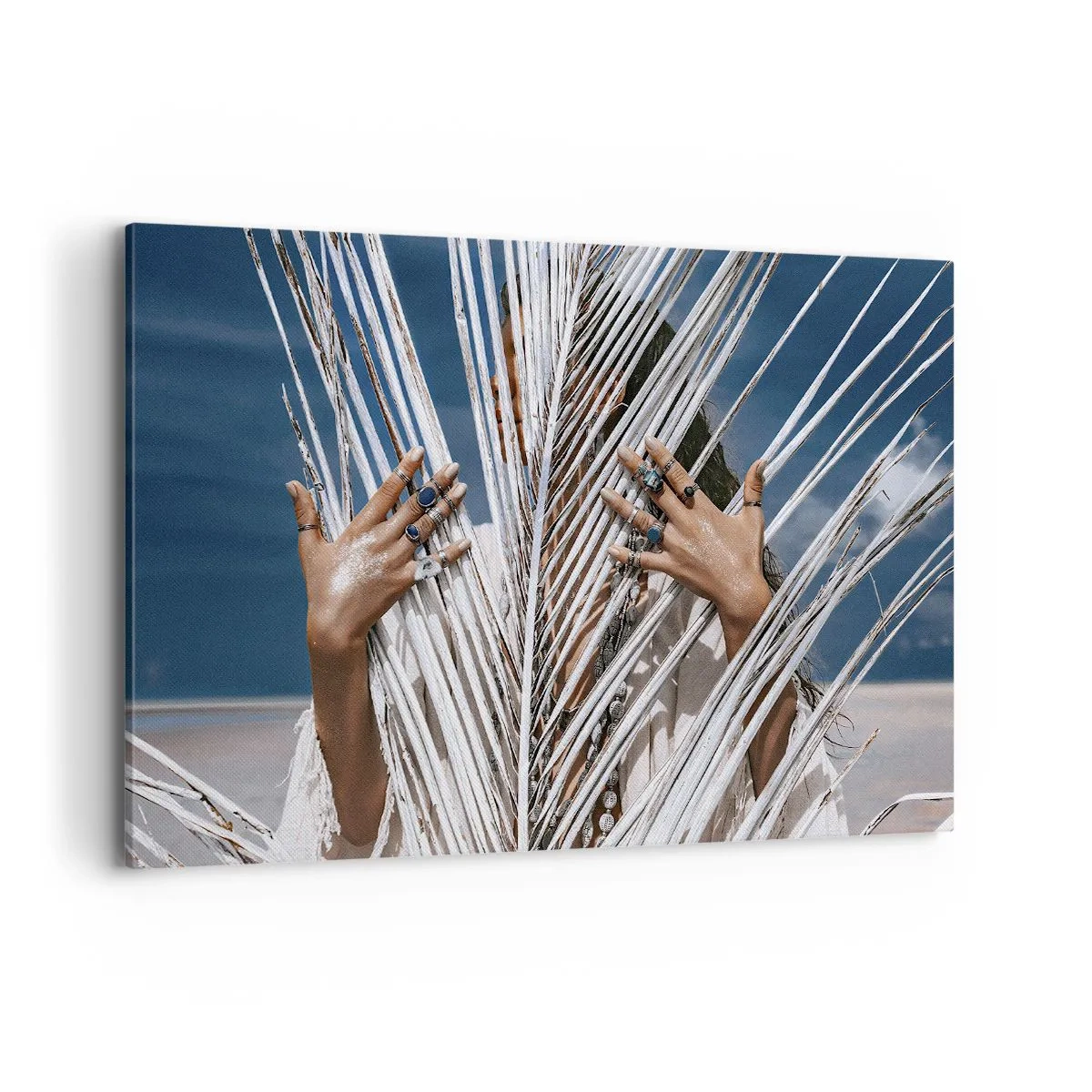Bild auf Leinwand - Leinwandbild - Eine Frau, versteckt hinter Palmblättern, mit Ringen an den Händen. - 120x80cm - Das Mädchen des Schamanen? - Moderne Wanddekoration für Wohnzimmer und Schlafzimmer ARTTOR