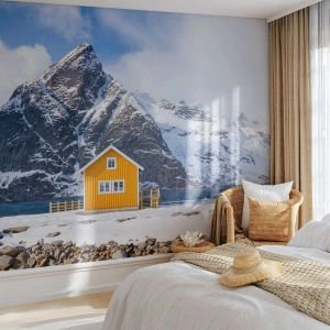 Fototapete Premium Canvas - Ein gelbes Haus vor der Kulisse schneebedeckter Berge und des Meeres - 100x70cm - Skandinavische Feiertage - Moderne Wanddekoration für Wohnzimmer und Schlafzimmer ARTTOR