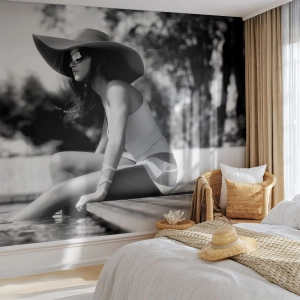 Fototapete Premium Sand - Eine Frau mit Hut sitzt am Pool - 100x70cm - Sommertraum - Moderne Wanddekoration für Wohnzimmer und Schlafzimmer ARTTOR