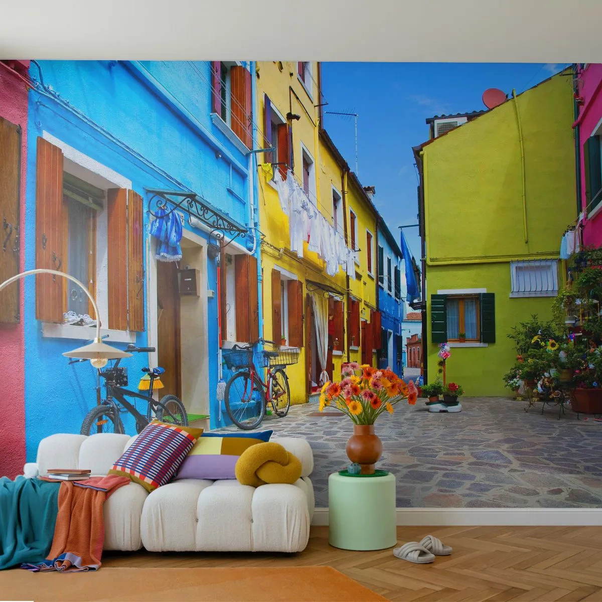 Fototapete Premium Sand - Eine bunte Straße mit Fahrrädern und Blumen im mediterranen Stil - 100x70cm - Pastell, süße Gasse - Moderne Wanddekoration für Wohnzimmer und Schlafzimmer ARTTOR