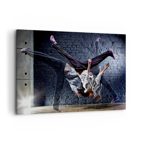Bild auf Leinwand - Leinwandbild - Eine Tänzerin bei einem dynamischen Sprung gegen eine Ziegelmauer - 120x80cm - Straßenstar - Moderne Wanddekoration für Wohnzimmer und Schlafzimmer ARTTOR