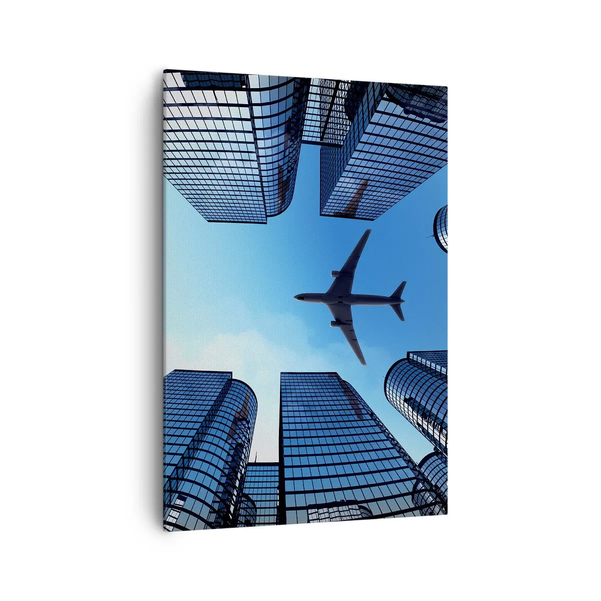 Bild auf Leinwand - Leinwandbild - Ein Flugzeug fliegt über moderne Wolkenkratzer im Stadtzentrum. - 70x100cm - Der Blick aus der Glasschlucht - Moderne Wanddekoration für Wohnzimmer und Schlafzimmer ARTTOR