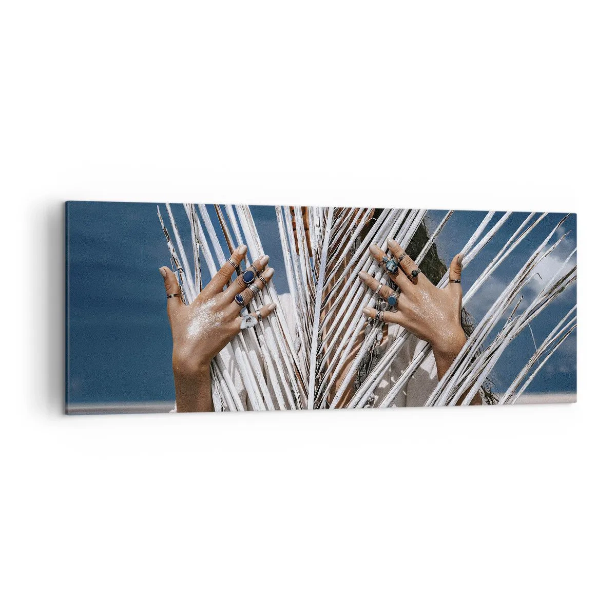 Bild auf Leinwand - Leinwandbild - Eine Frau, versteckt hinter Palmblättern, mit Ringen an den Händen. - 140x50cm - Das Mädchen des Schamanen? - Moderne Wanddekoration für Wohnzimmer und Schlafzimmer ARTTOR