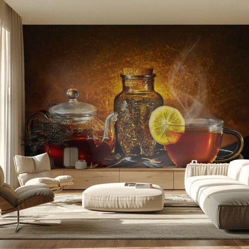 Fototapete Standard Eco - Eine Glaskanne und eine Tasse Tee mit Zitrone auf goldenem Hintergrund. - 100x70cm - Im Stil der niederländischen Meister - Moderne Wanddekoration für Wohnzimmer und Schlafzimmer ARTTOR