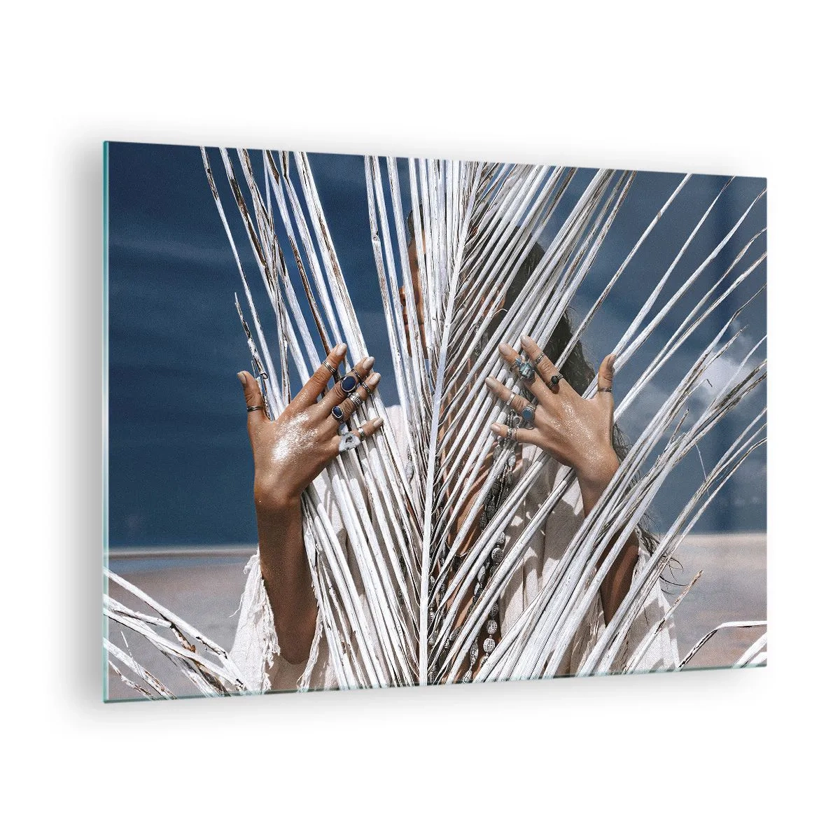Glasbild - Bild auf glas - Mit Ringen geschmückte Frauenhände hinter einer trockenen Palme - 70x50cm - Das Mädchen des Schamanen? - Moderne Wanddekoration für Wohnzimmer und Schlafzimmer ARTTOR