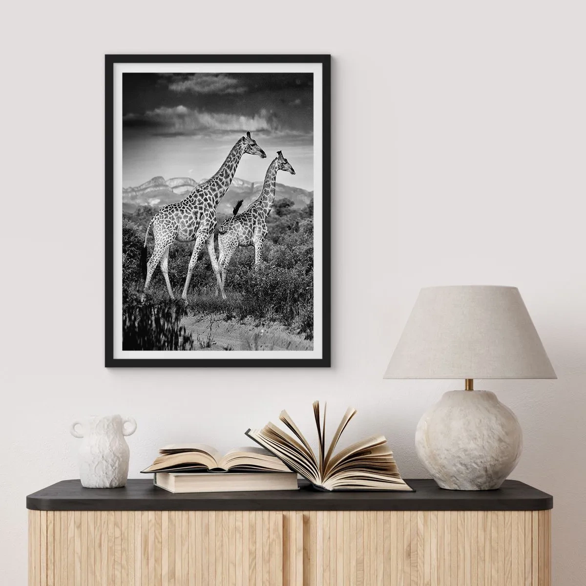 Poster in einem schwarzem Rahmen - Schwarz-Weiß-Porträt von Giraffen vor dem Hintergrund einer afrikanischen Landschaft - 50x70cm - Hohe Sphären in Afrika - Moderne Wanddekoration für Wohnzimmer und Schlafzimmer ARTTOR