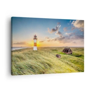 Bild auf Leinwand - Leinwandbild - Ein Leuchtturm mit Wiesen und Häusern in der Sonne im Hintergrund - 70x50cm - Zwischen den Wellen - Moderne Wanddekoration für Wohnzimmer und Schlafzimmer ARTTOR