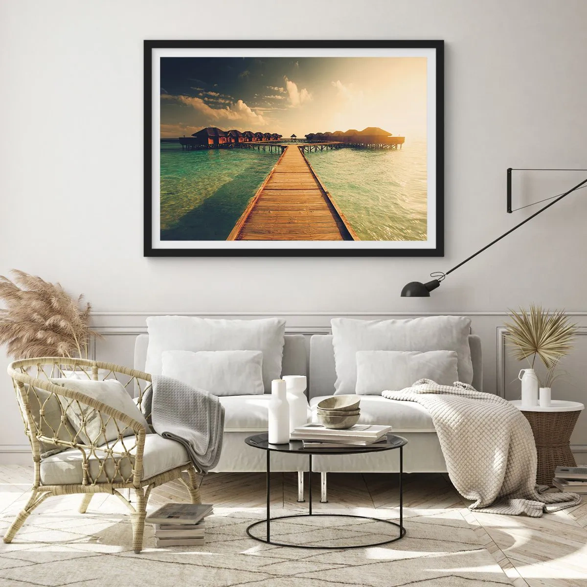 Poster in einem schwarzem Rahmen - Ein Holzsteg führt zu den Häusern am Wasser, beleuchtet von den Sonnenstrahlen. - 70x50cm - Eine herzliche Einladung - Moderne Wanddekoration für Wohnzimmer und Schlafzimmer ARTTOR