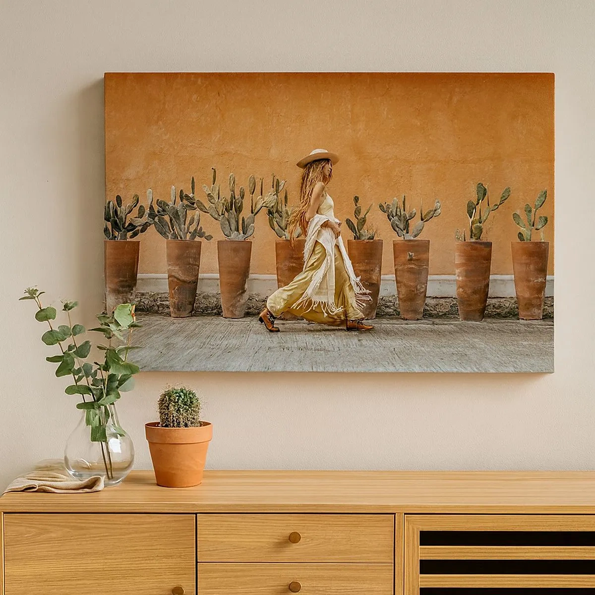 Bild auf Leinwand - Leinwandbild - Eine Frau im Boho-Stil mit Töpfen voller Kakteen im Hintergrund. - 70x50cm - Hippie-Stil - Moderne Wanddekoration für Wohnzimmer und Schlafzimmer ARTTOR