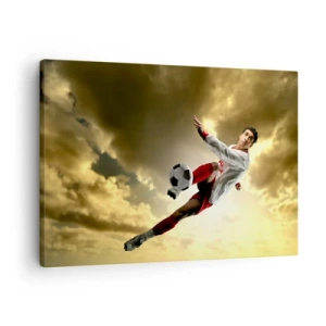 Bild auf Leinwand - Leinwandbild - Ein Fußballspieler in einem dynamischen Sprung kickt den Ball in den Himmel - 70x50cm - Fußballhimmel - Moderne Wanddekoration für Wohnzimmer und Schlafzimmer ARTTOR