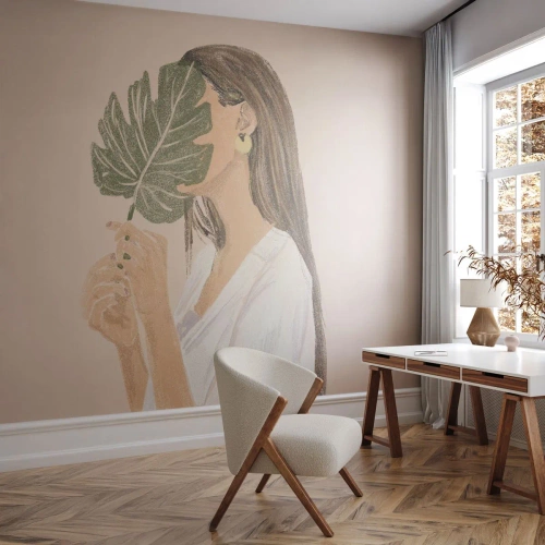 Fototapete Premium Canvas - Porträt einer Frau mit einem Monstera-Blatt auf beigem Hintergrund - 100x70cm - Geheimnisvolles Porträt mit Fächer - Moderne Wanddekoration für Wohnzimmer und Schlafzimmer ARTTOR
