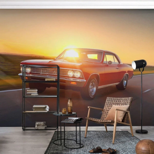 Fototapete Premium Canvas - Ein rotes Auto in der untergehenden Sonne auf einer offenen Straße - 100x70cm - Begehren ist rot - Moderne Wanddekoration für Wohnzimmer und Schlafzimmer ARTTOR