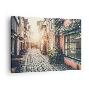 Bild auf Leinwand - Leinwandbild - Eine charmante Straße mit Steinpflaster und Blumen - 70x50cm - Rosenallee im rosa Schein - Moderne Wanddekoration für Wohnzimmer und Schlafzimmer ARTTOR