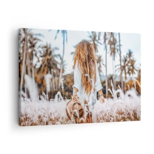 Bild auf Leinwand - Leinwandbild - Eine Frau auf einer Wiese mit Palmen im Hintergrund bei Sonnenuntergang - 70x50cm - Geboren aus Grasflaum - Moderne Wanddekoration für Wohnzimmer und Schlafzimmer ARTTOR