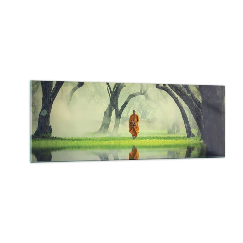 Glasbild - Bild auf glas - Ein Mönch in einer orangefarbenen Robe in einem Wald mit nebligem Hintergrund und Spiegelung im Wasser. - 140x50cm - Auf dem Weg zur Erleuchtung - Moderne Wanddekoration für Wohnzimmer und Schlafzimmer ARTTOR